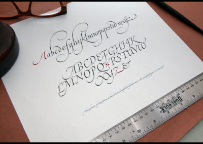 Alphabet and quote: in Italic calligraphy on paper